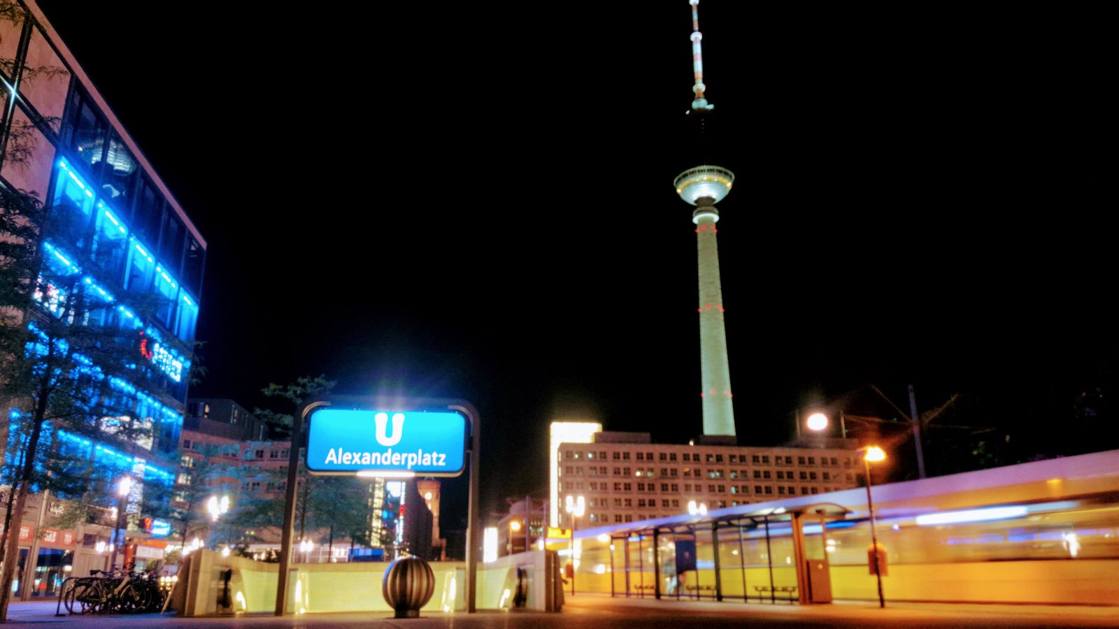 Alexanderplatz at night with a moving tram and the TV Tower in Berlin