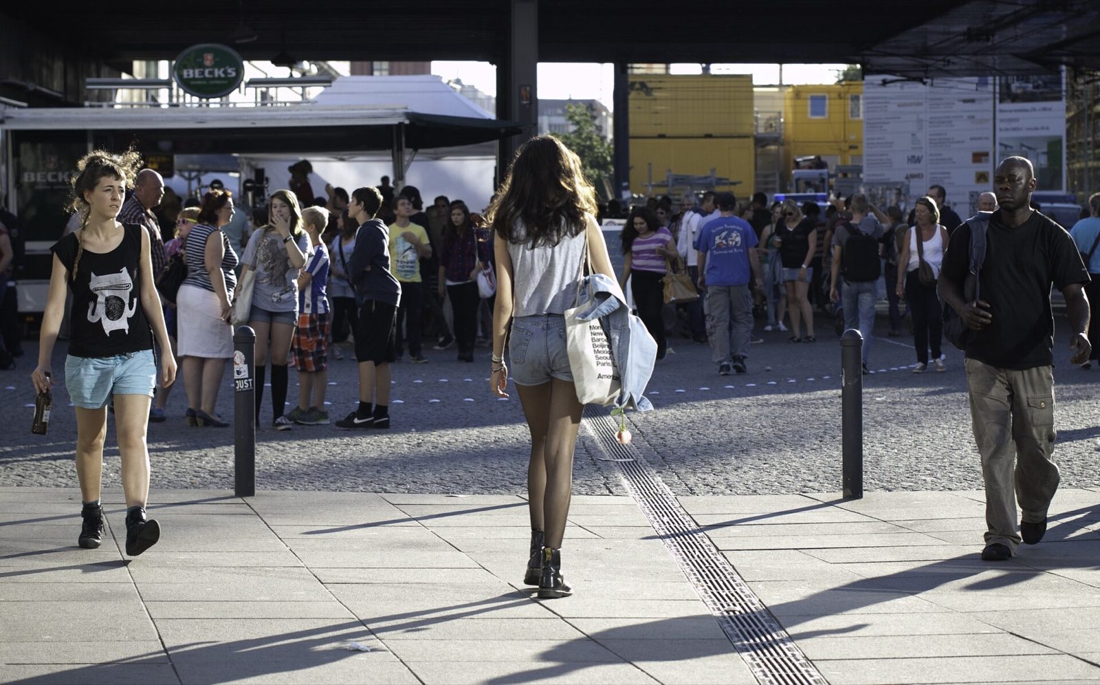 People walking across Alexanderplatz in Berlin with the TV Tower behind them